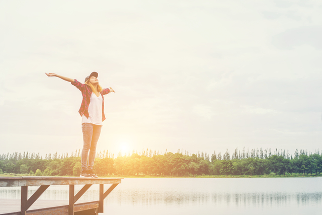 Hoeveel moet ik verzekeren voor mijn uitvaart? - gelukkige vrouw bij het water